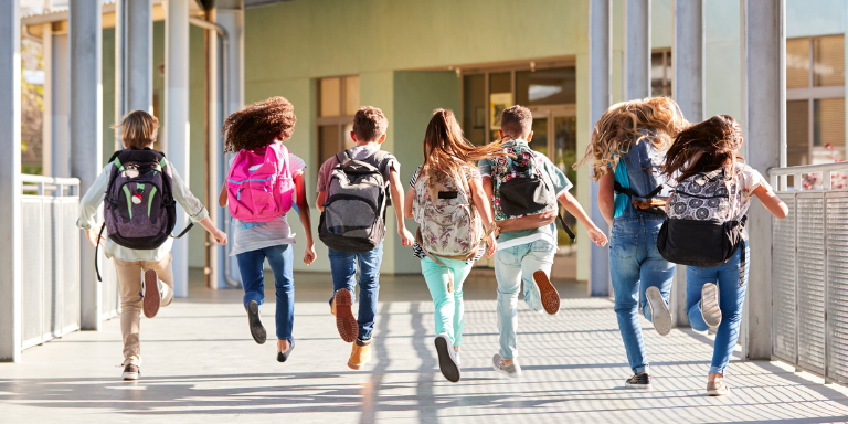 Sept enfants courent dans la cour d'une école.