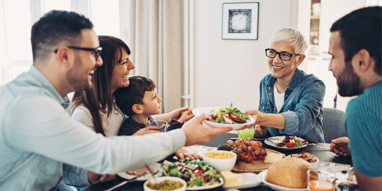 Une famille est assise à la table du dîner et mange.