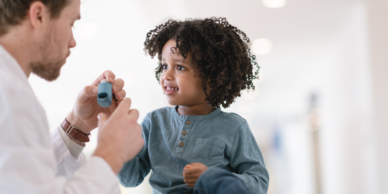 Un medico insegna a un bambino come inspirare.